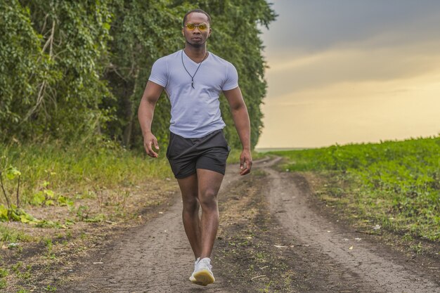 Young man walking alone at sunset