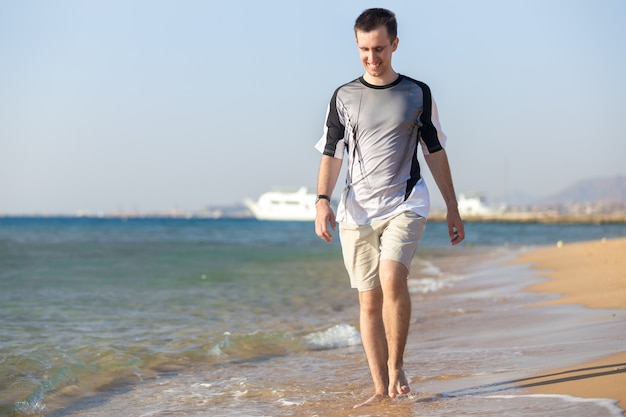 해안선에 걷는 젊은 남자