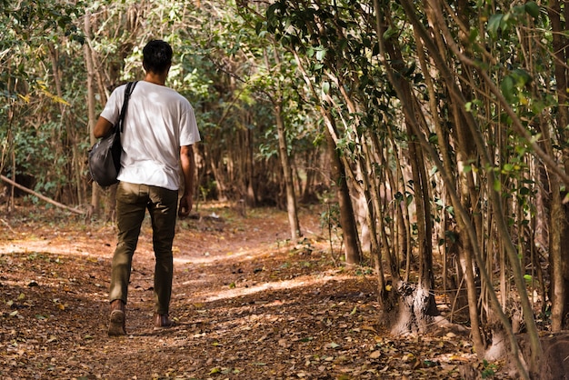 Молодой человек гуляет в лесу