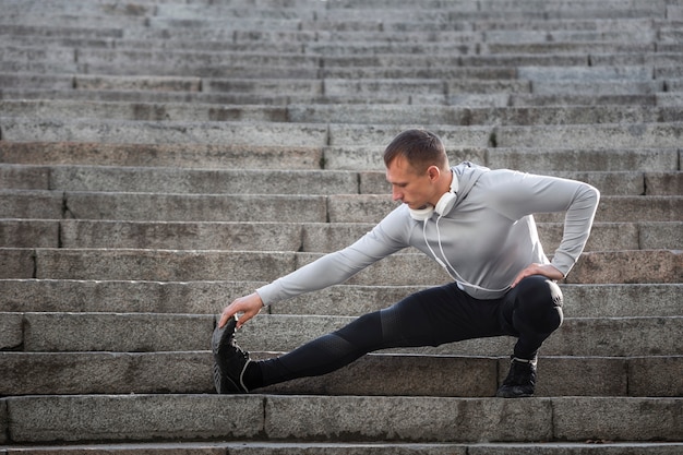 Young man warming up on stairs