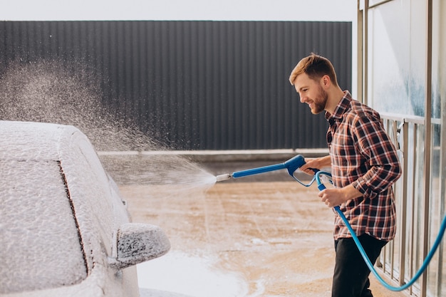 무료 사진 carwash에서 그의 차를 세척하는 젊은 남자