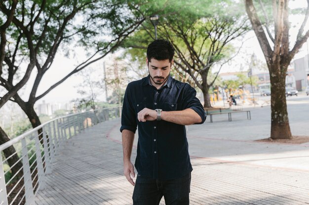 Young man watching time in park