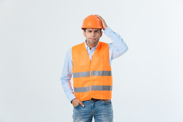 Young man wearing architect outfit and helmet with angry face, negative dislike emotion. Angry and rejection concept.