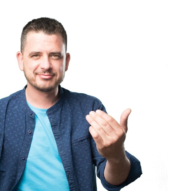 Young man wearing a blue outfit. Doing a inviting gesture.