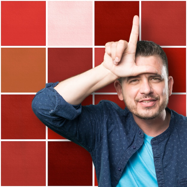 Young man wearing a blue outfit. Doing looser gesture.