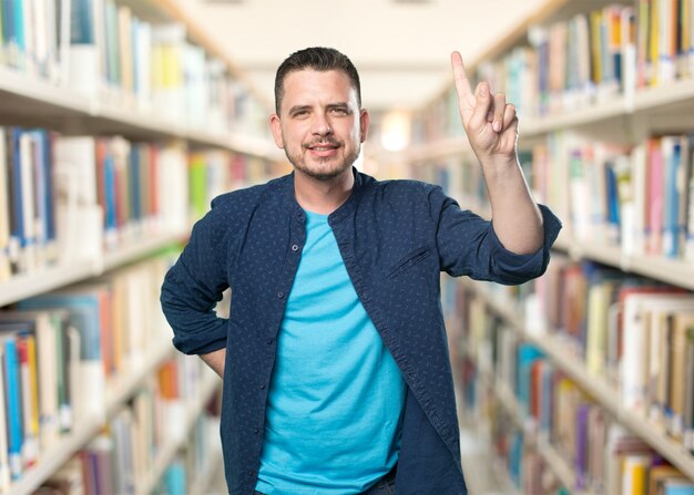 青い服を着ている若い男。 1番号ジェスチャーを行います。