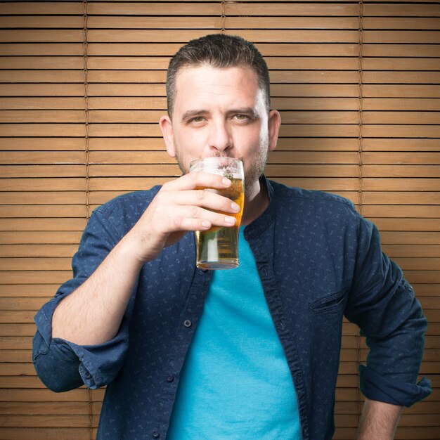 Молодой человек, одетый в синий наряд. Пью пиво.