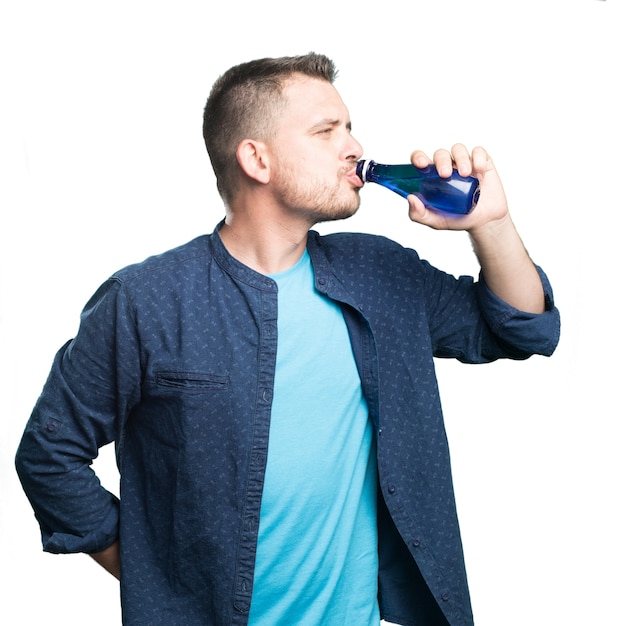 Free photo young man wearing a blue outfit. drinking water.