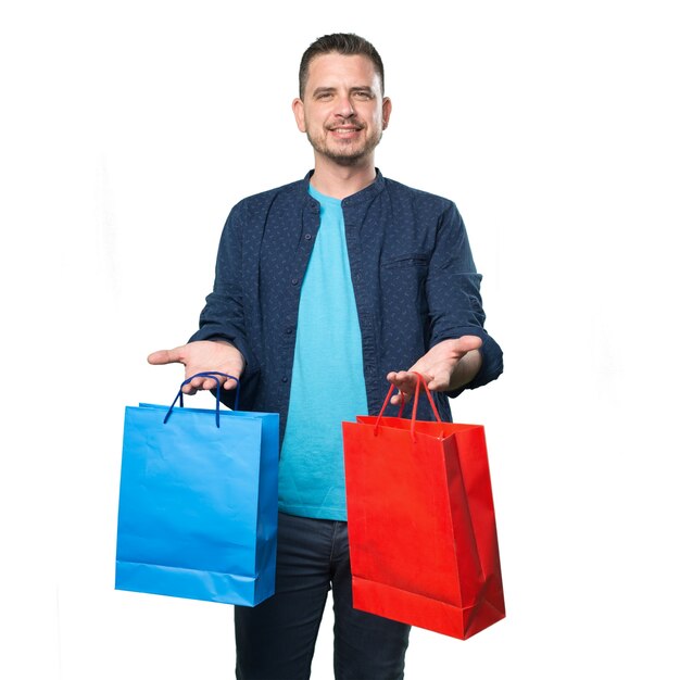 青い服を着ている若い男。買い物袋を保持しています。