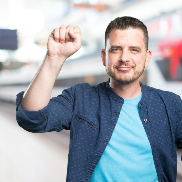 Young man wearing a blue outfit. Knocking gesture.