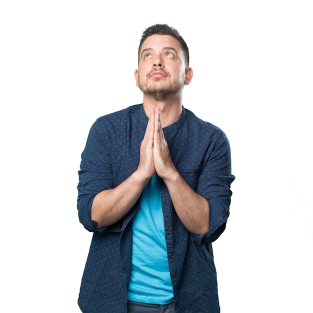 Free photo young man wearing a blue outfit. look praying.