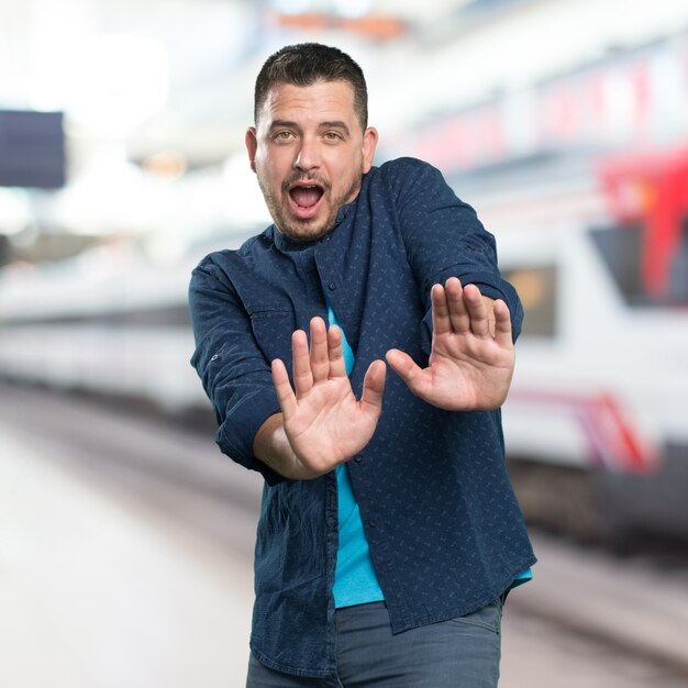 Young man wearing a blue outfit. looking afraid.