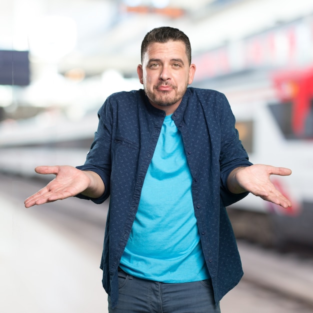 Foto gratuita giovane uomo che indossa un vestito blu. guardando confuso.