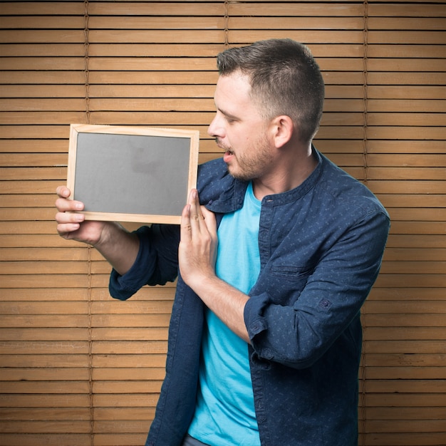 Young man wearing a blue outfit. Looking into board.