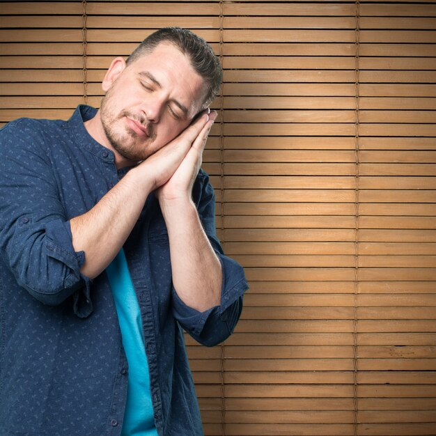 Young man wearing a blue outfit. Looking sleepy.