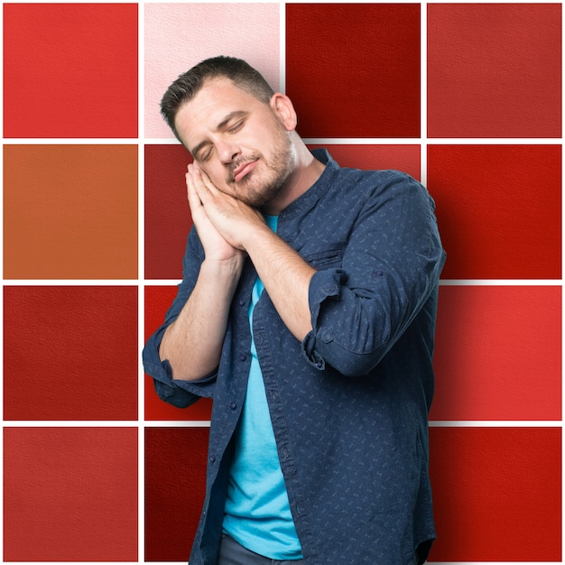 Young man wearing a blue outfit. Looking sleepy.