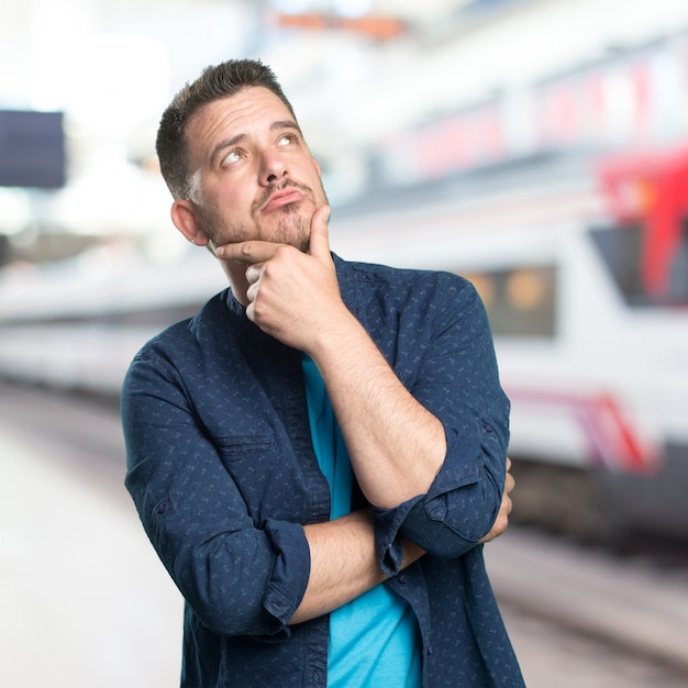 Young man wearing a blue outfit. Looking thoughful.