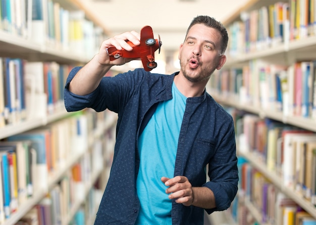 Young man wearing a blue outfit. Playing with a plane.