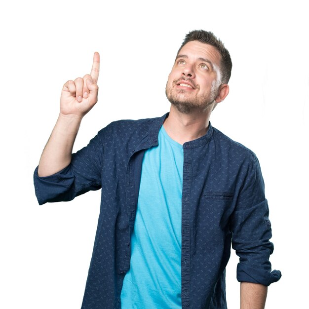 Young man wearing a blue outfit. Pointing up with his finger.