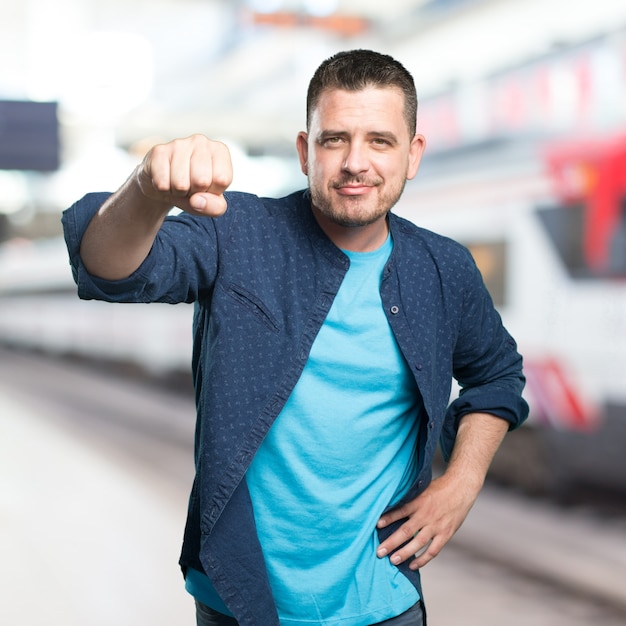 Free photo young man wearing a blue outfit. showing confident his fist.