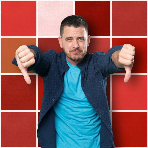 Young man wearing a blue outfit. With both thumbs down.