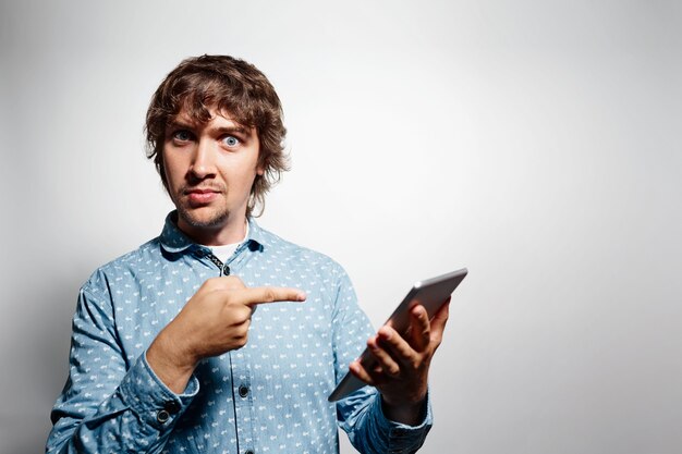 Young man wearing blue shirt and holding tablet