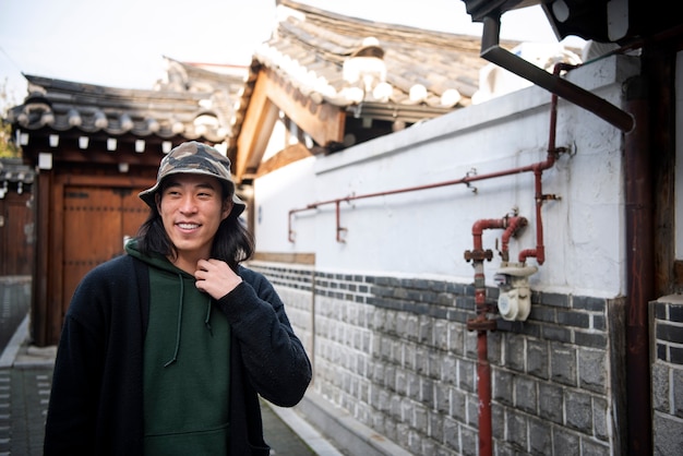 Free photo young man wearing a bucket hat in the city