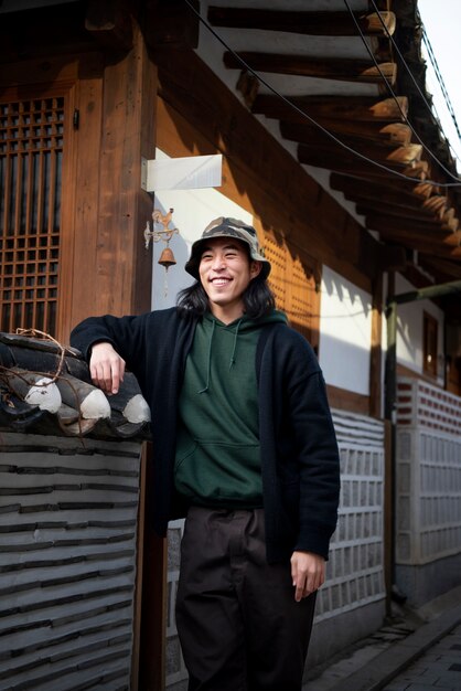 街でバケツ帽子をかぶった青年
