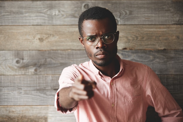 Free photo young man wearing eyeglasses and pink shirt