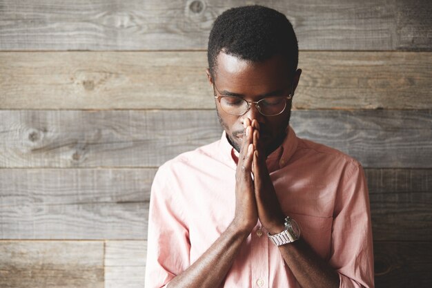 young man wearing eyeglasses and pink shirt