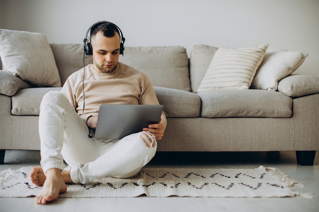 Young man wearing headphones and using computer at home