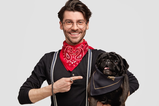 Young man wearing red bandana and black shirt holding dog