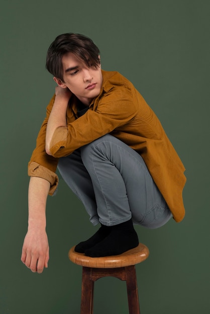 Young man wearing shirt posing on chair