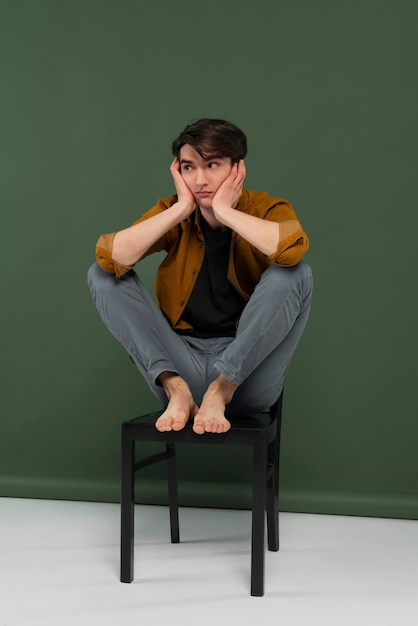 Young man wearing shirt posing on chair