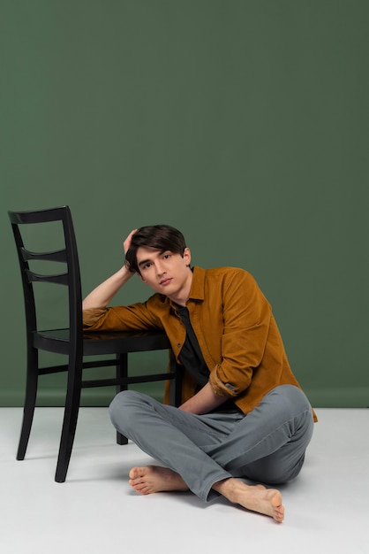 Free photo young man wearing shirt posing on chair