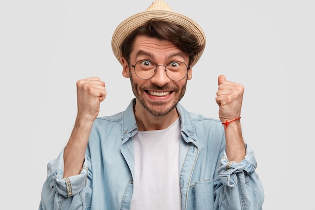 Foto gratuita giovane uomo che indossa cappello di paglia e camicia di jeans