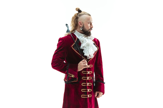 Free photo the young man wearing a traditional medieval costume of marquis posing at studio with whip. fantasy, antique, renaissance concept