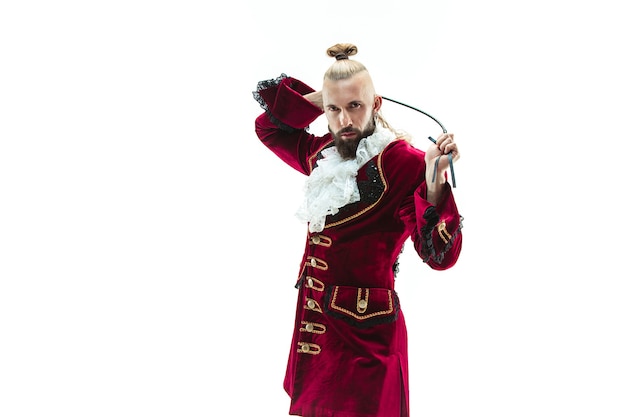 Free photo the young man wearing a traditional medieval costume of marquis posing at studio with whip.