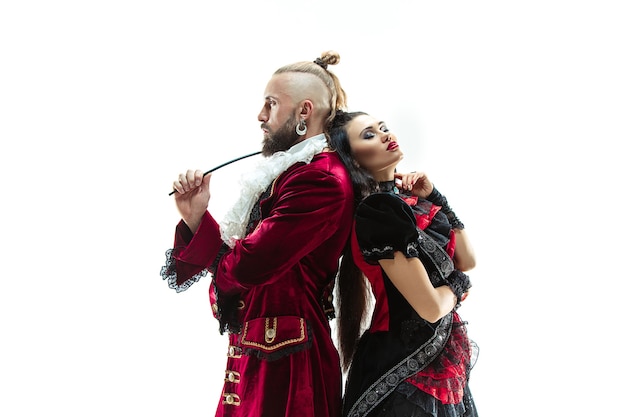 Free photo the young man wearing a traditional medieval costume of marquis posing at studio with woman as marquise. fantasy, antique, renaissance concept