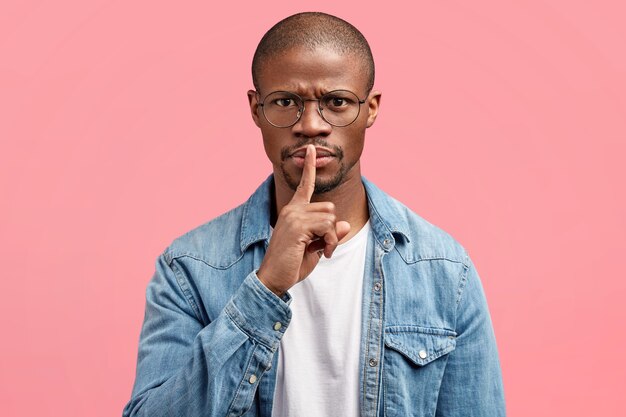 Young man wearing trendy eyeglasses and denim shirt