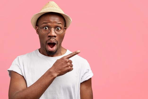 Young man wearing trendy eyeglasses and straw hat