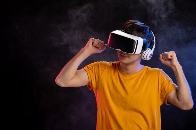 Young man wearing virtual reality headset on dark surface