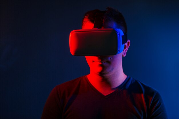 Молодой человек, носящий гарнитуру VR и испытывающий виртуальную реальность.