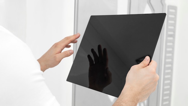 Young man wearing white clothes using tablet close up