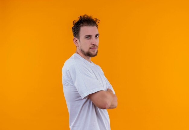  young man wearing white t-shirt crossing hands on isolated orange wall