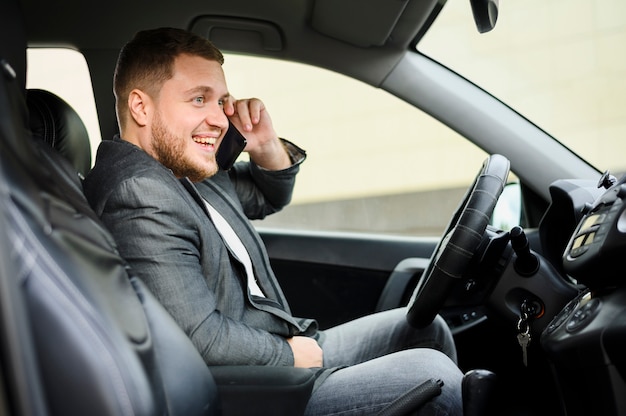 Young man at the wheel with his phone on his ear