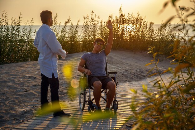Молодой человек в инвалидной коляске и его врач.