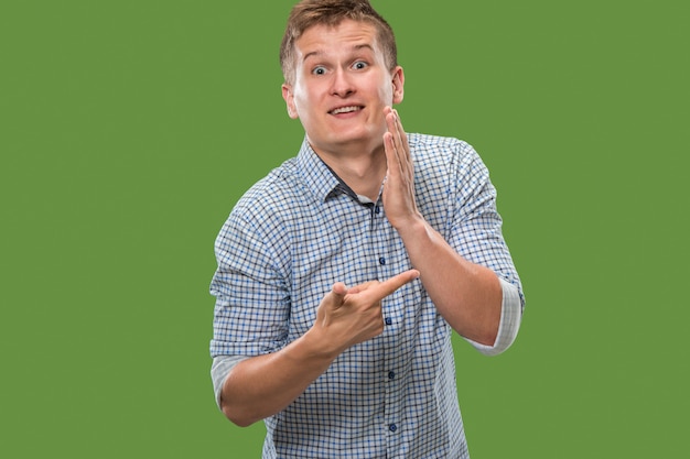 Free photo the young man whispering a secret behind her hand over green background