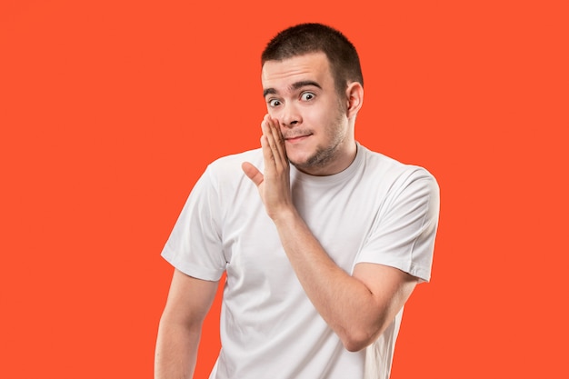 The young man whispering a secret behind her hand over orange