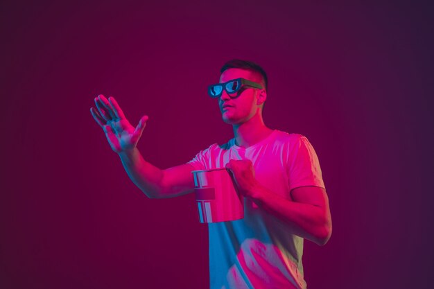 Young man with 3D glasses and popcorn bucket